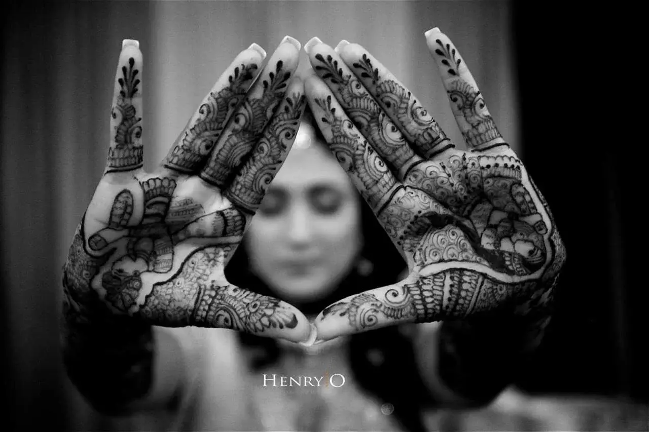 Bride displaying intricate mehndi on palms with hands outstretched
